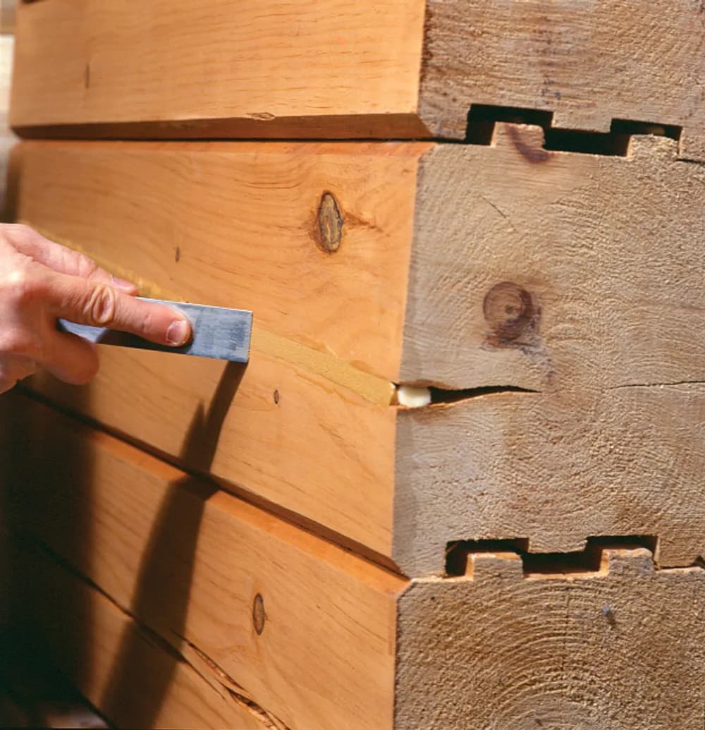 Sealing a log check with Sashco Conceal textured caulk