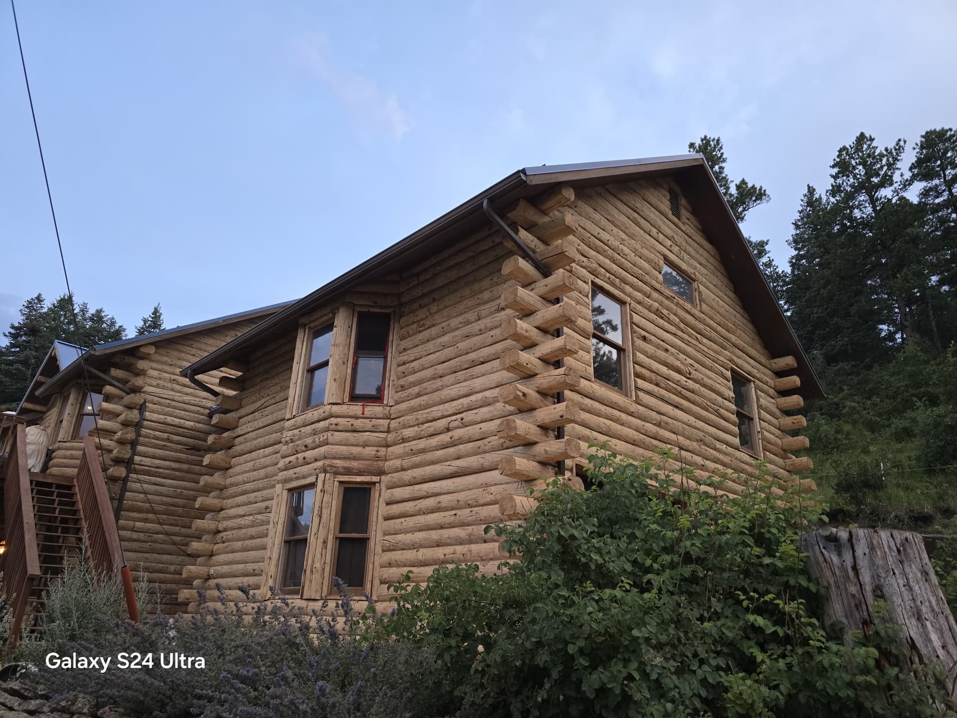 Before: Painted log home exterior before walnut shell media blasting restoration in Rye Colorado. After: Clean bare logs with natural wood grain revealed ready for professional staining