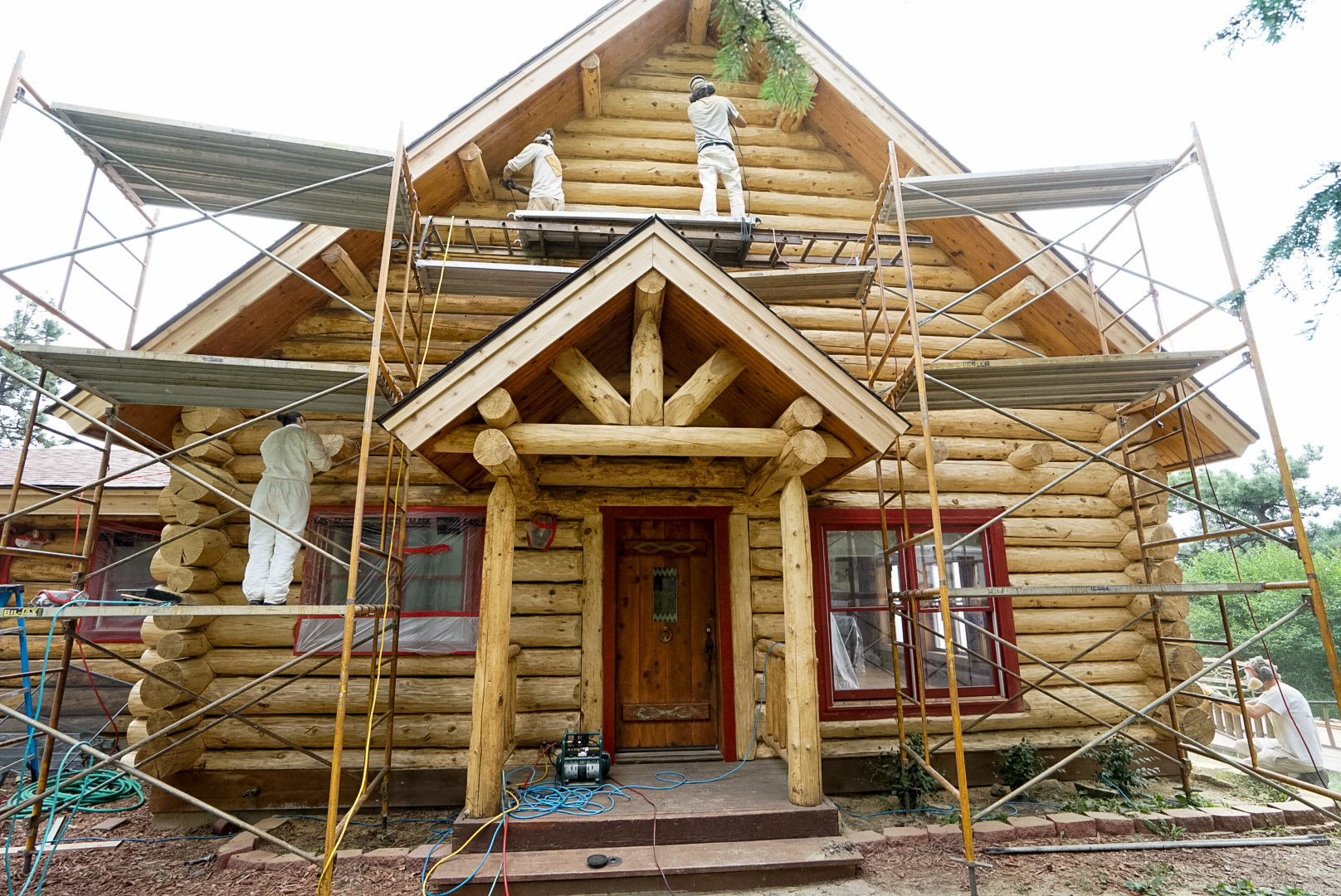 Professional log home restoration project in Evergreen, Colorado showing scaffolding and restoration work in progress