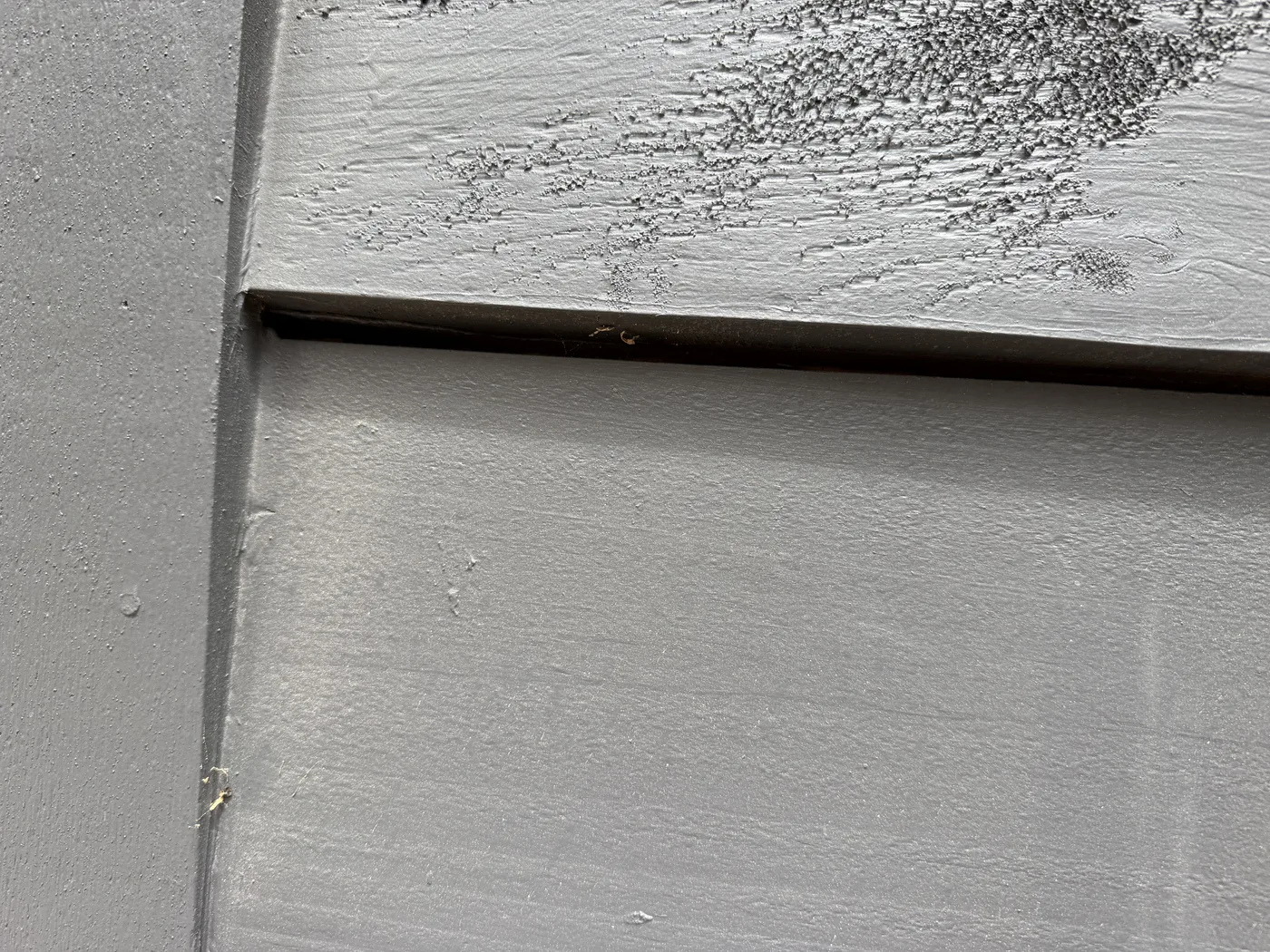 Wide open horizontal reveal between grey log siding boards with the heavy-bodied <a href=