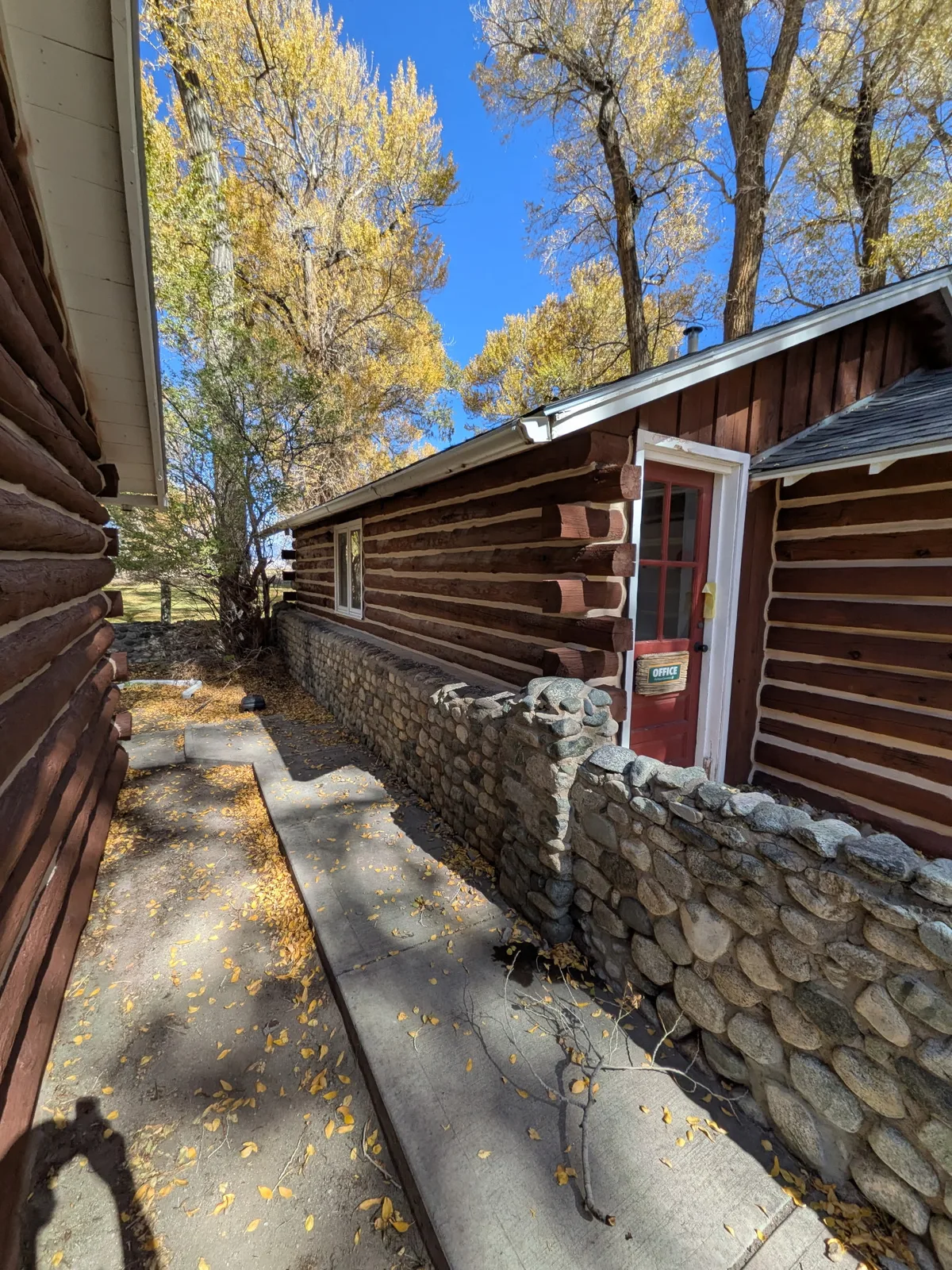 Projecting log ends and light chinking beside a narrow stone-lined walkway