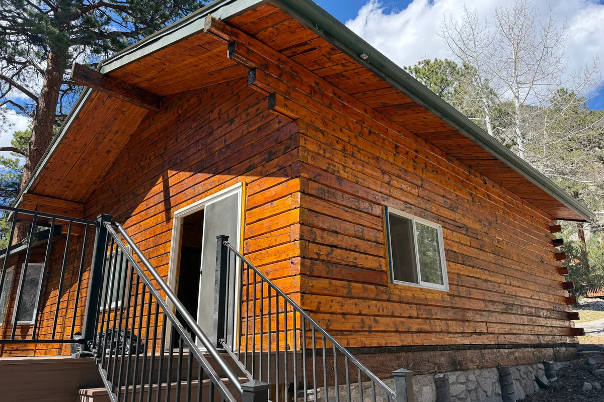 Professional log home staining service in Colorado showing expert application of Sashco Symphony and Permachink stain systems for UV protection